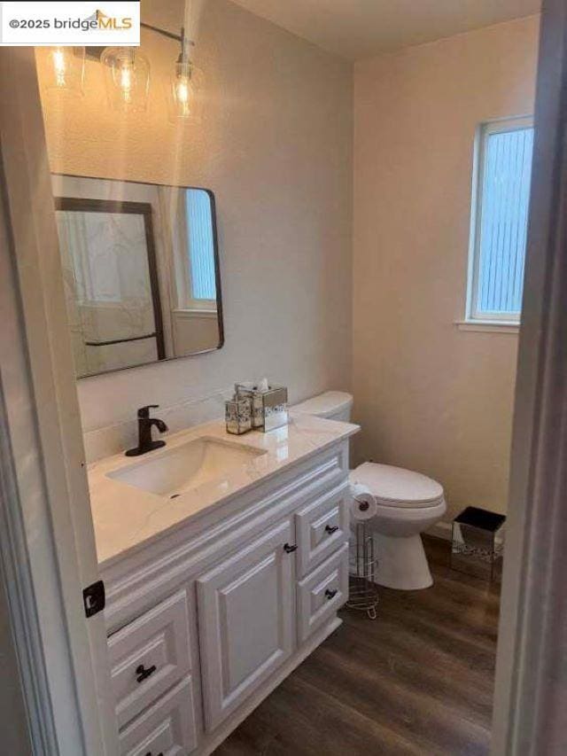 bathroom featuring vanity, hardwood / wood-style floors, and toilet