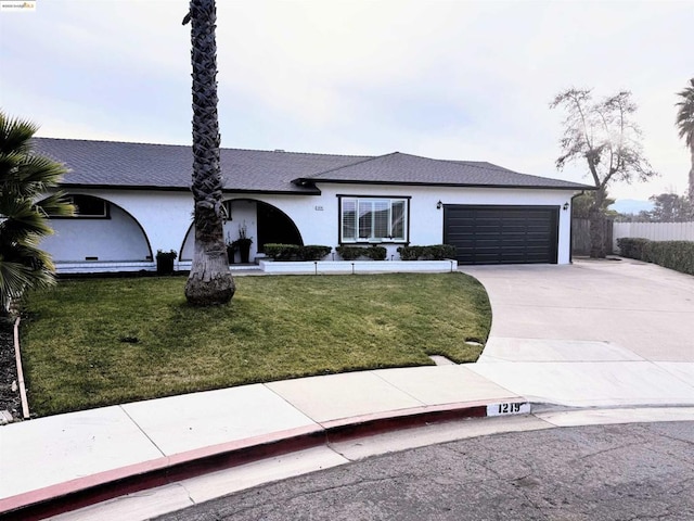 ranch-style home featuring a garage and a front lawn