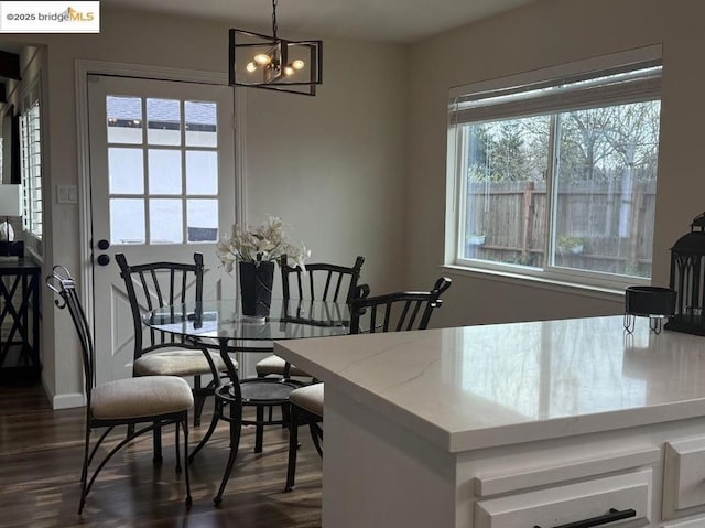 dining area featuring dark wood-type flooring and a chandelier