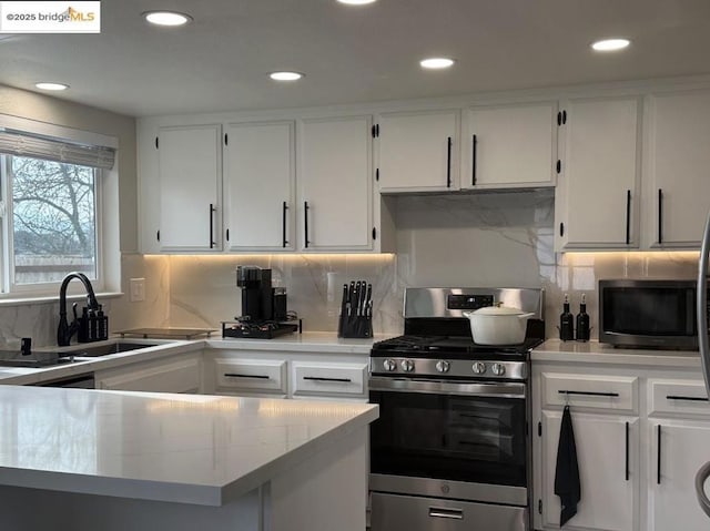 kitchen with white cabinetry, sink, backsplash, and appliances with stainless steel finishes