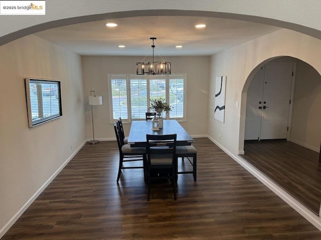 dining space featuring dark hardwood / wood-style flooring and a notable chandelier