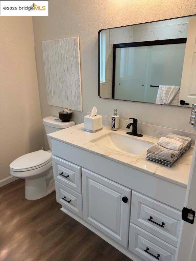 bathroom featuring vanity, hardwood / wood-style flooring, and toilet