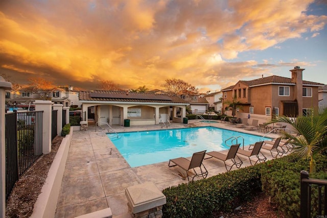 pool at dusk featuring a patio