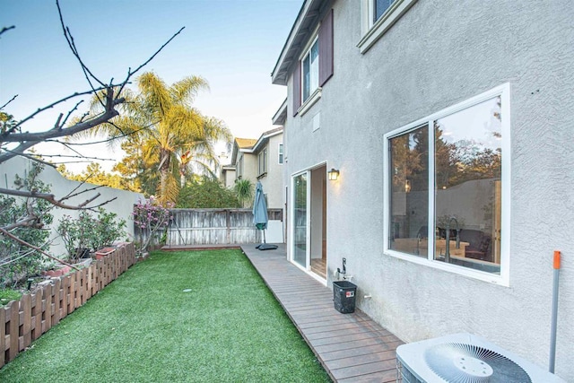 view of yard with a fenced backyard and central AC unit