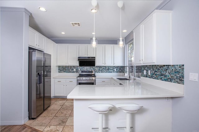 kitchen featuring stainless steel appliances, backsplash, a sink, ventilation hood, and a peninsula