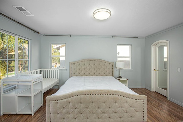 bedroom featuring wood finished floors, visible vents, and multiple windows