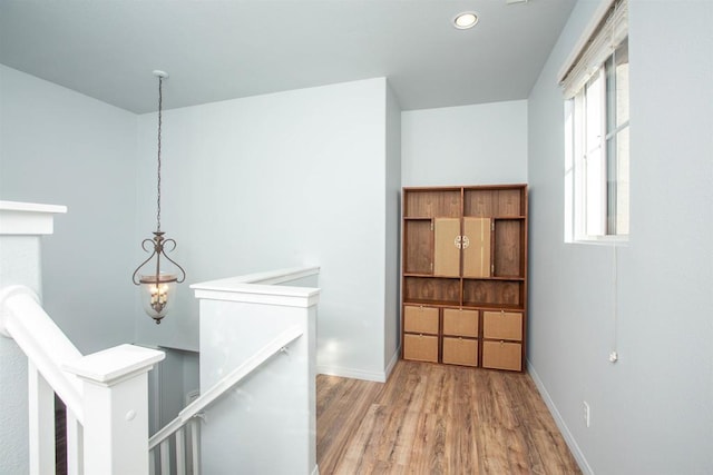 corridor featuring recessed lighting, wood finished floors, an upstairs landing, and baseboards