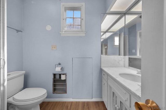 bathroom with vanity, hardwood / wood-style floors, plenty of natural light, and toilet