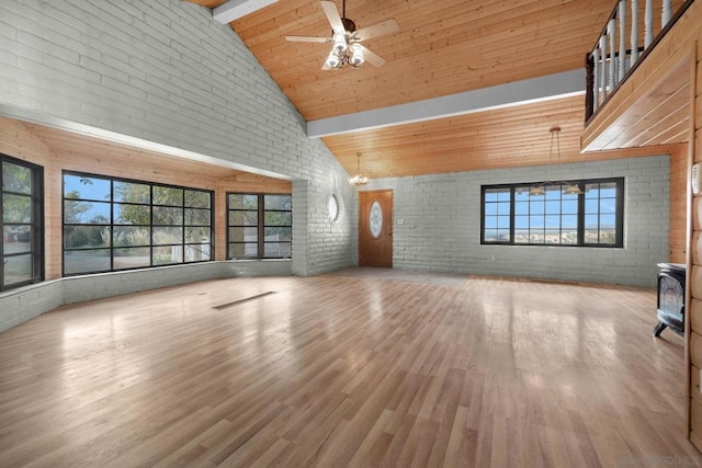 unfurnished living room featuring hardwood / wood-style floors, beam ceiling, high vaulted ceiling, and brick wall