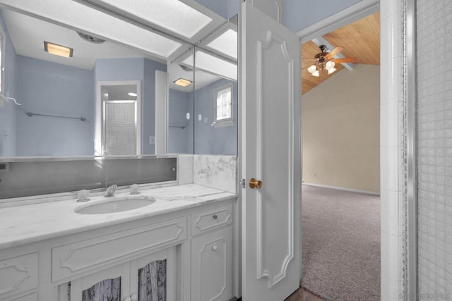 bathroom with ceiling fan, lofted ceiling, and vanity