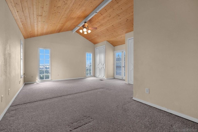 carpeted empty room featuring ceiling fan, beamed ceiling, wooden ceiling, and a healthy amount of sunlight