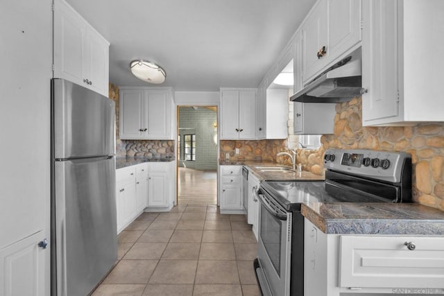 kitchen with white cabinetry, sink, decorative backsplash, light tile patterned floors, and stainless steel appliances