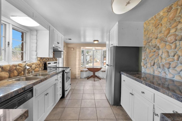 kitchen featuring stainless steel appliances, sink, light tile patterned floors, and white cabinets