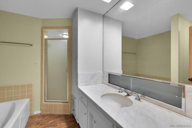 bathroom featuring wood-type flooring, separate shower and tub, and vanity