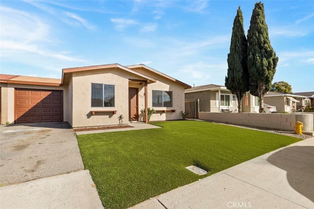 ranch-style house with a garage and a front lawn