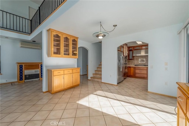 kitchen featuring a wall mounted air conditioner, appliances with stainless steel finishes, decorative backsplash, and light tile patterned floors