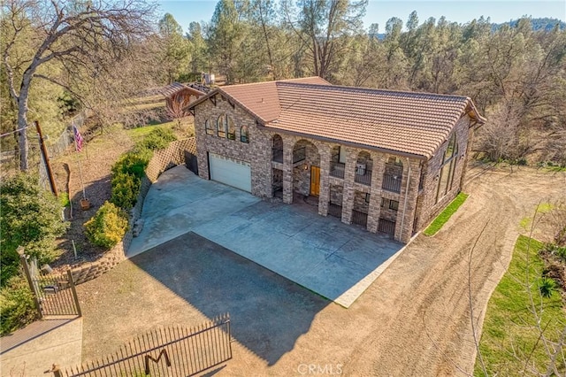 15796 Joseph Trl, Lower Lake, CA 95457 - view of front facade with driveway, a tiled roof, stone siding, a garage, and a chimney