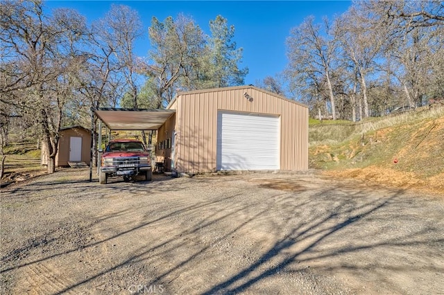 garage featuring a detached garage, driveway, and a shed