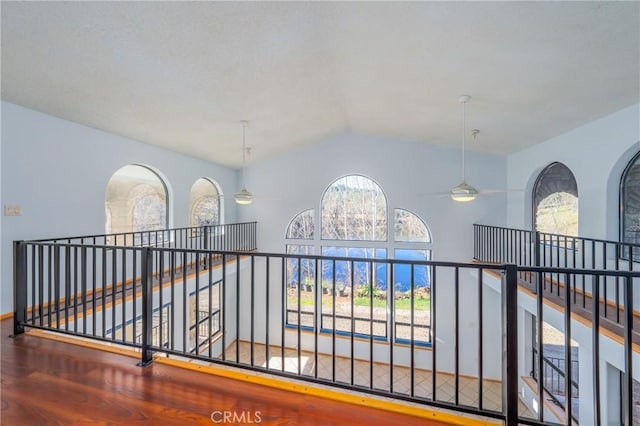 hall featuring wood-type flooring and vaulted ceiling