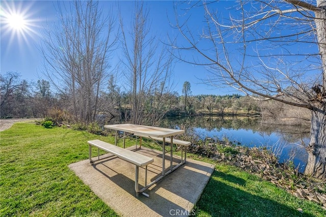 view of community with a lawn and a water view
