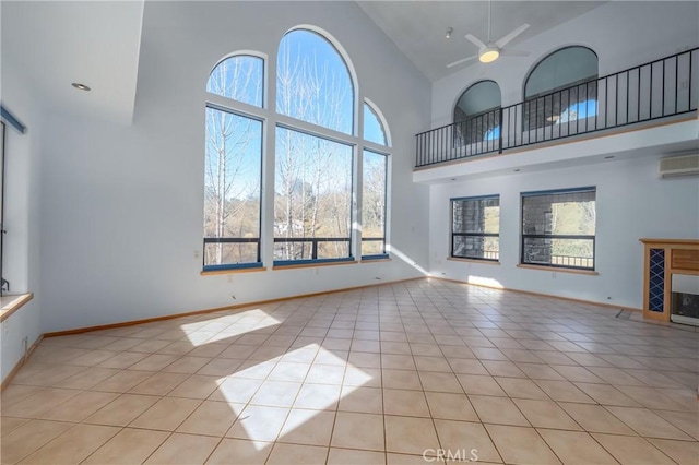 unfurnished living room featuring a ceiling fan, light tile patterned floors, high vaulted ceiling, baseboards, and an AC wall unit
