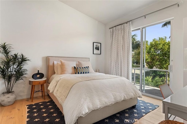 bedroom with access to exterior, vaulted ceiling, and light wood-type flooring