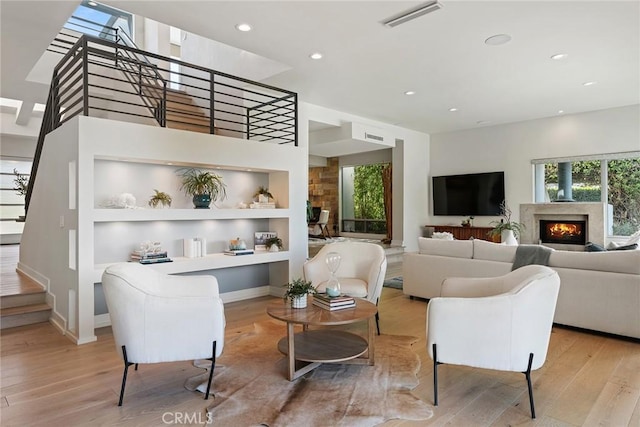 living room featuring a healthy amount of sunlight, light hardwood / wood-style floors, and built in features