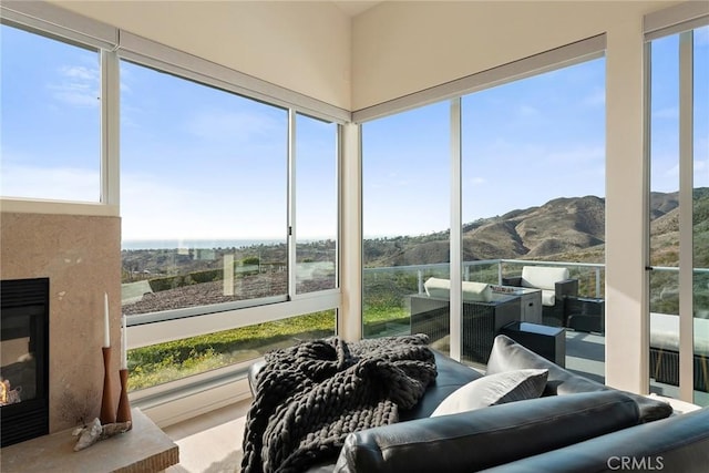 sunroom featuring a premium fireplace and a mountain view