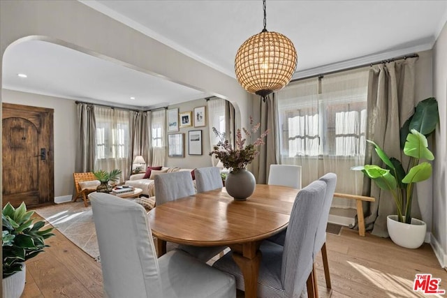 dining space featuring ornamental molding and light wood-type flooring