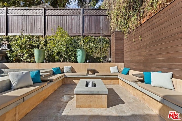 view of patio / terrace featuring an outdoor living space with a fire pit