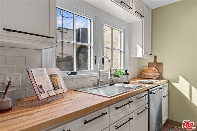 kitchen with white cabinetry, wood counters, sink, and tasteful backsplash