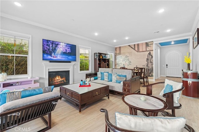 living room with ornamental molding and light hardwood / wood-style floors