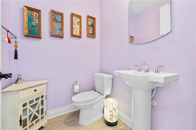 bathroom with hardwood / wood-style flooring and toilet