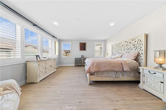 bedroom featuring multiple windows and light hardwood / wood-style flooring