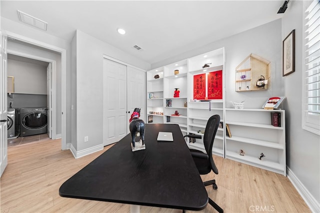 office area featuring washing machine and clothes dryer and light hardwood / wood-style flooring