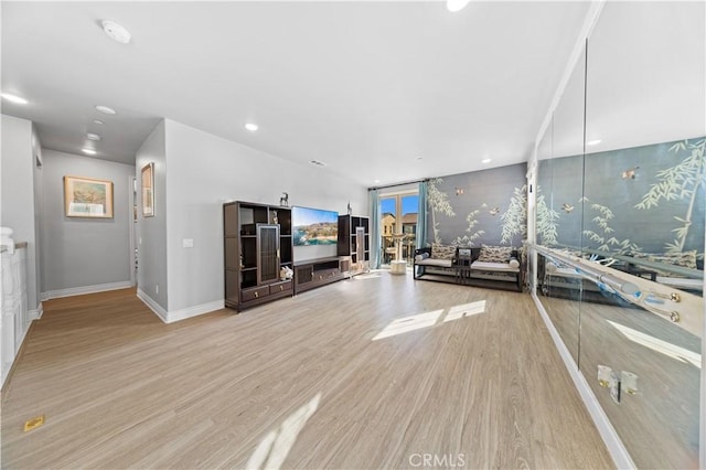 exercise area with a wall of windows and light hardwood / wood-style flooring