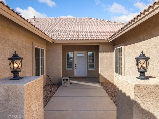 view of exterior entry with a patio area