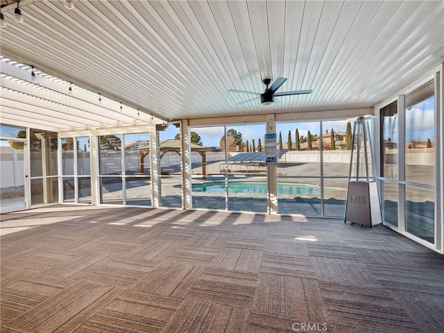 unfurnished sunroom featuring ceiling fan