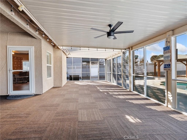 unfurnished sunroom featuring ceiling fan