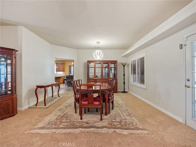 dining space featuring an inviting chandelier and carpet