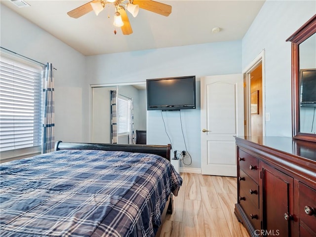 bedroom with multiple windows, a closet, ceiling fan, and light hardwood / wood-style floors