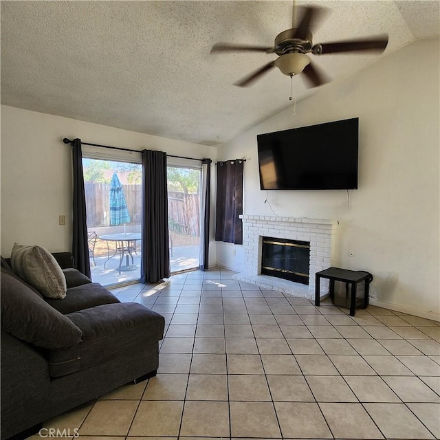 living room featuring vaulted ceiling, light tile patterned floors, a fireplace, and a textured ceiling