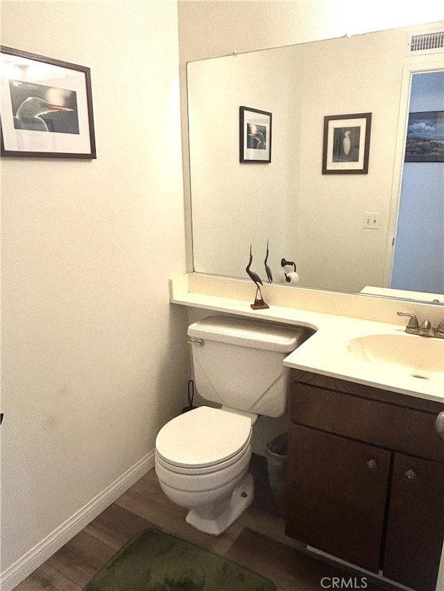 bathroom with wood-type flooring, toilet, and vanity