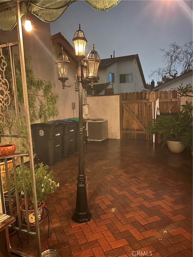 patio terrace at dusk featuring cooling unit