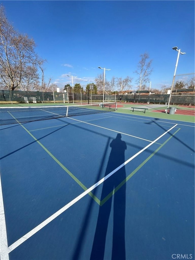 view of tennis court with basketball hoop