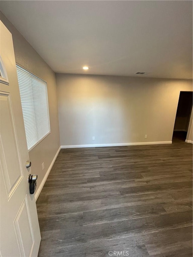 empty room with dark hardwood / wood-style flooring