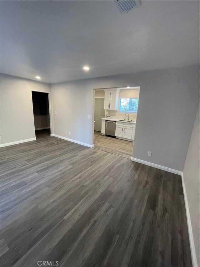 unfurnished living room featuring dark hardwood / wood-style floors and sink