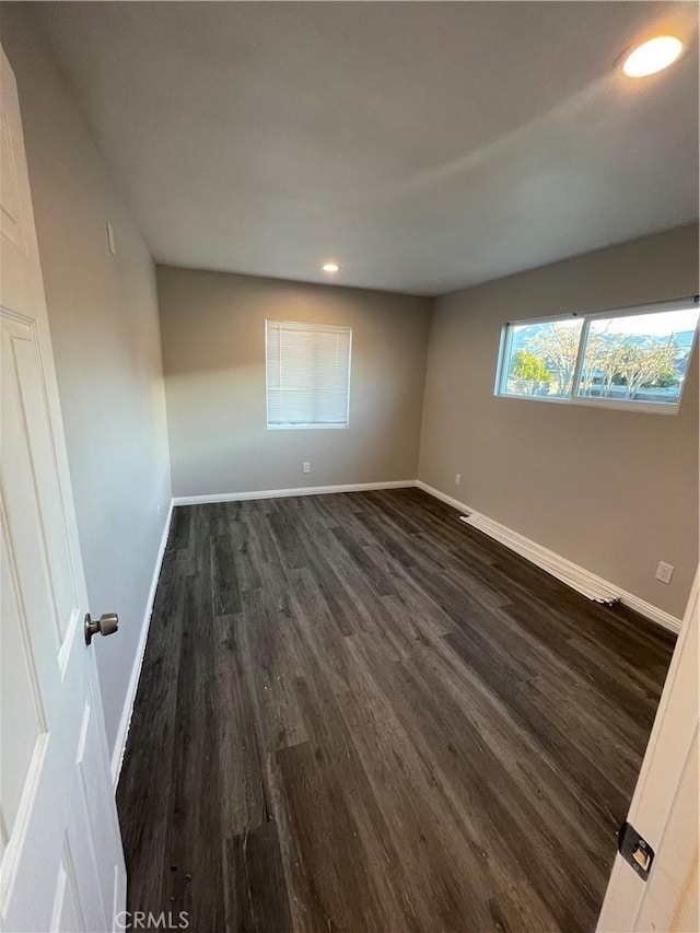 unfurnished room with dark wood-type flooring