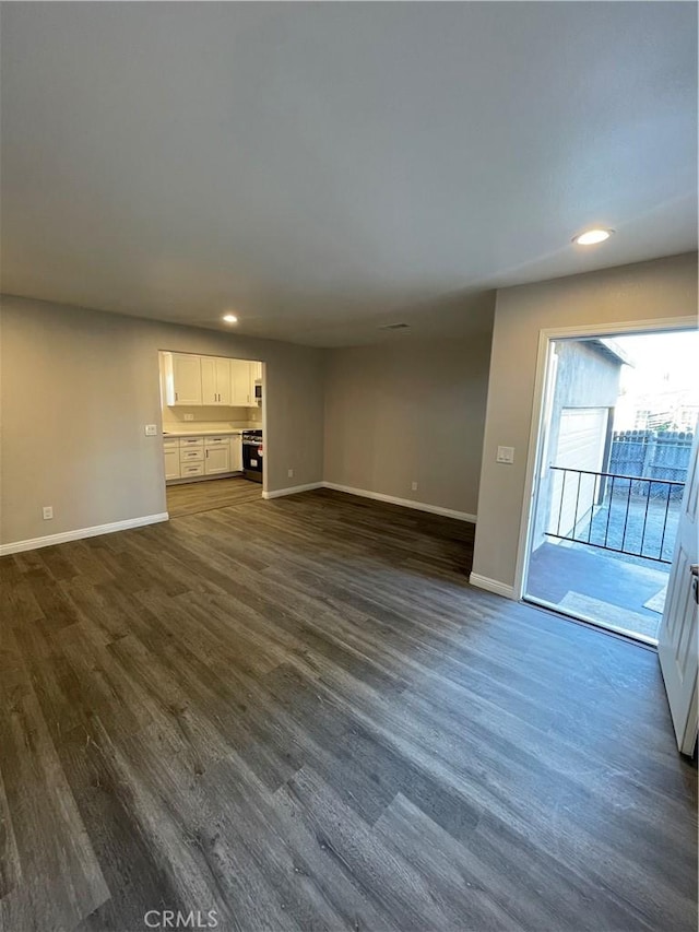 unfurnished living room with dark hardwood / wood-style flooring