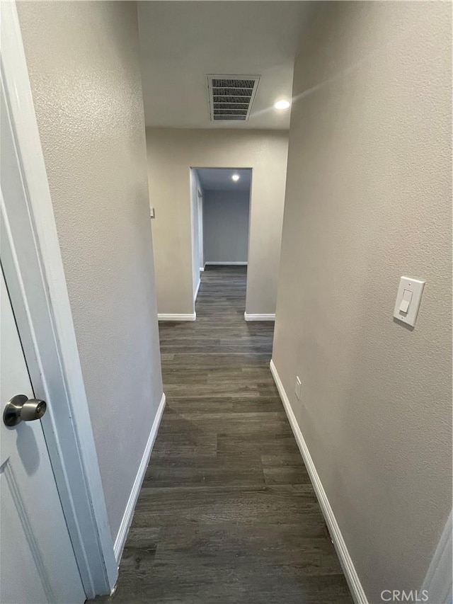 corridor with dark hardwood / wood-style flooring